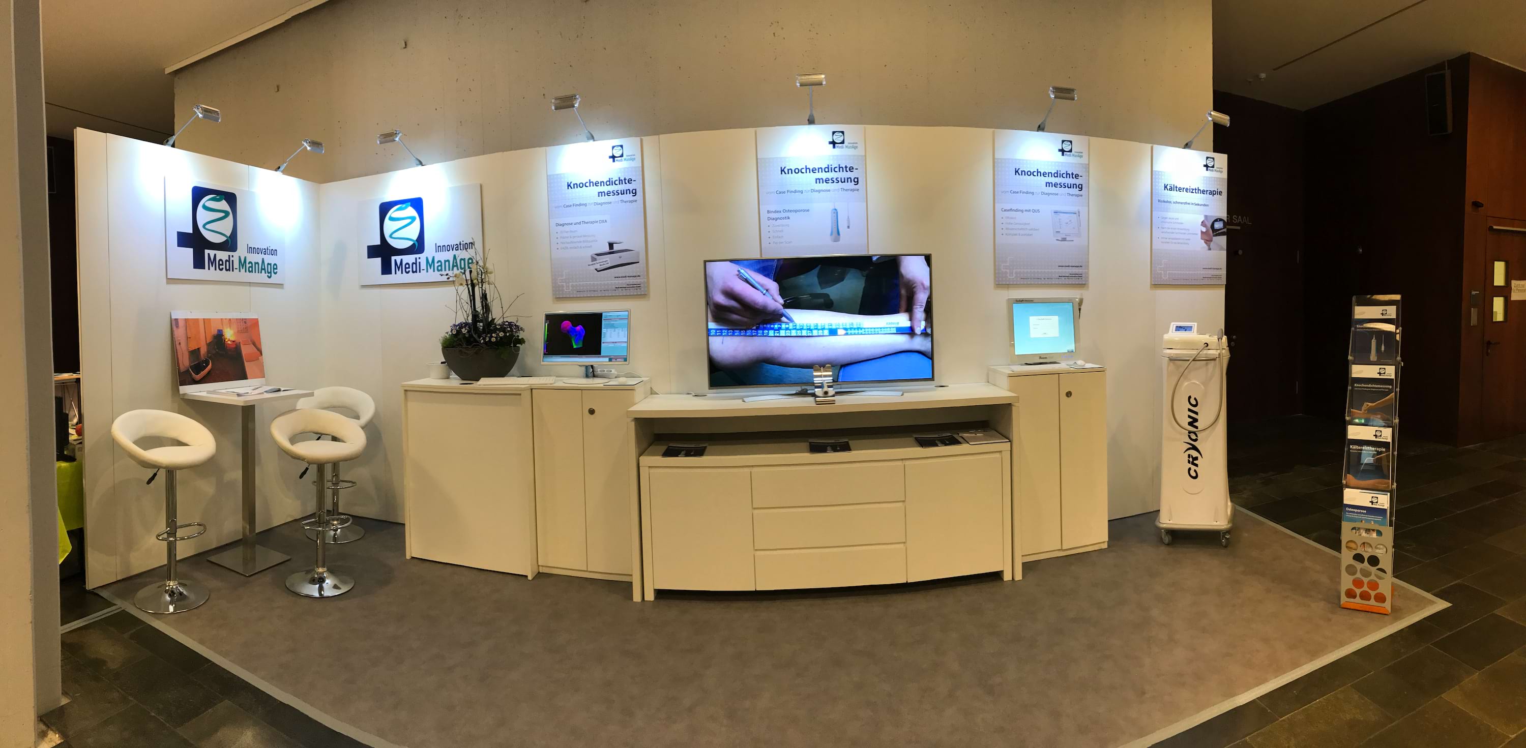 Medi-Manage Messestand mit Bildschirm und Geräten